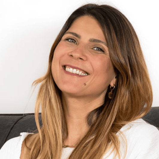 Lächelnde Frau mit langen Haaren auf dem Sofa